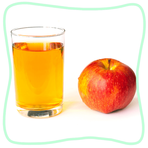 Un verre de jus de pomme et une pomme. 