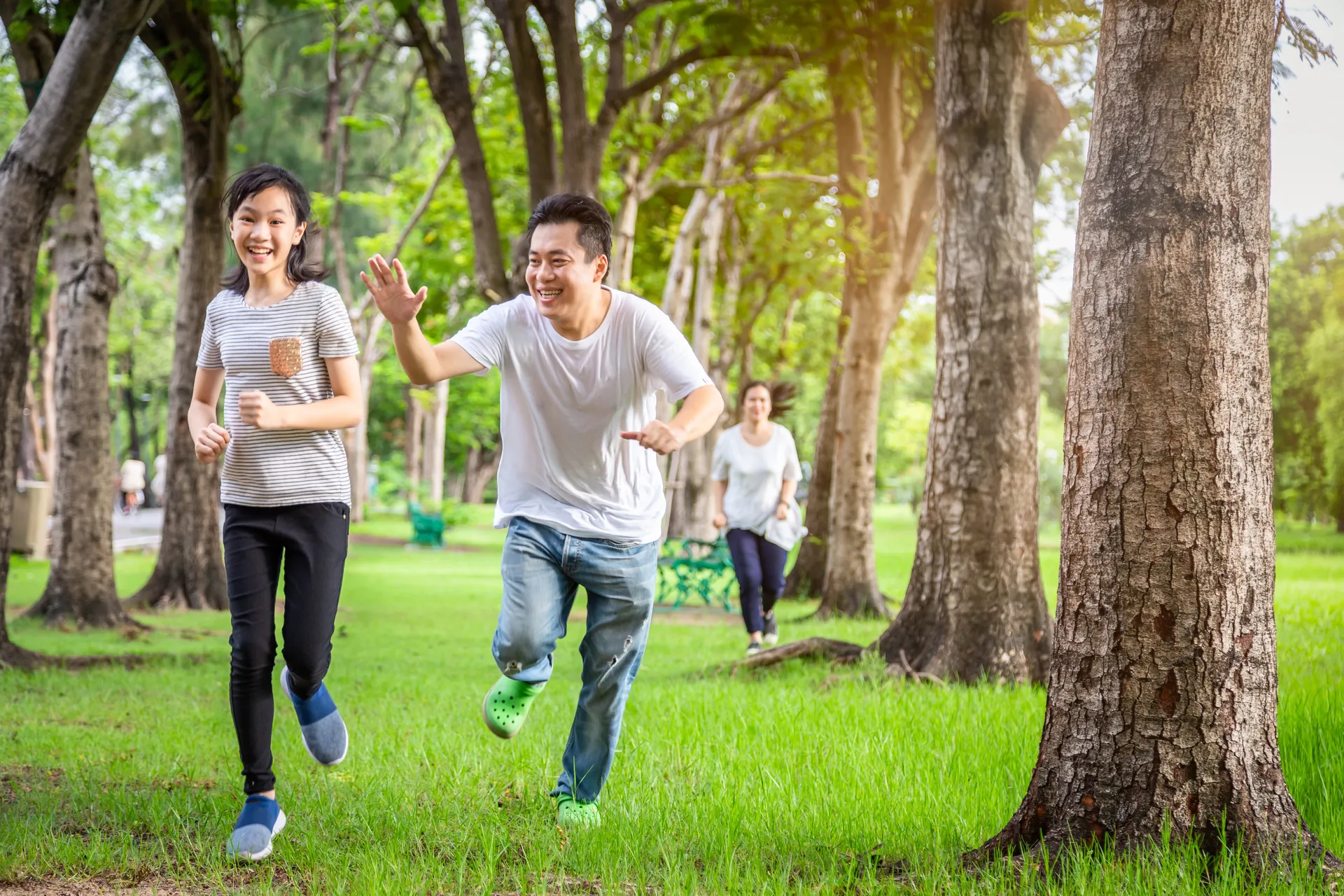 Trois personnes en train de courir dans un parc. 