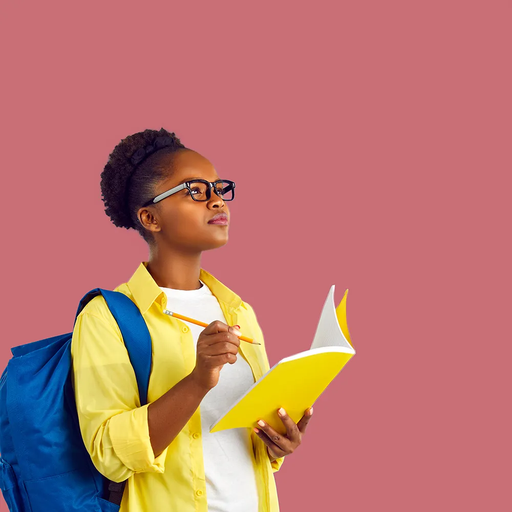 Photo d’une jeune fille qui tient un crayon et un carnet.  